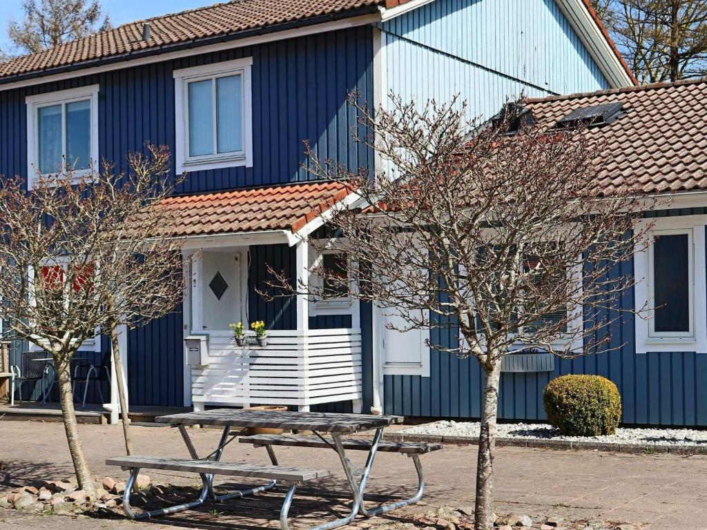 ein blaues Haus mit einem Picknicktisch davor in der Unterkunft Holiday home Halmstad VII in Halmstad