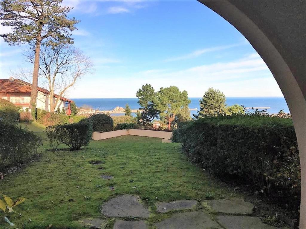 a view of a garden with the ocean in the background at Appartement Ciboure, 2 pièces, 4 personnes - FR-1-4-673 in Ciboure