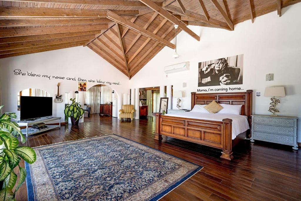 sypialnia z łóżkiem i telewizorem oraz drewnianym sufitem w obiekcie Hospitality Expert Mr X Suite - Tour Pool Bar Beach w mieście Montego Bay