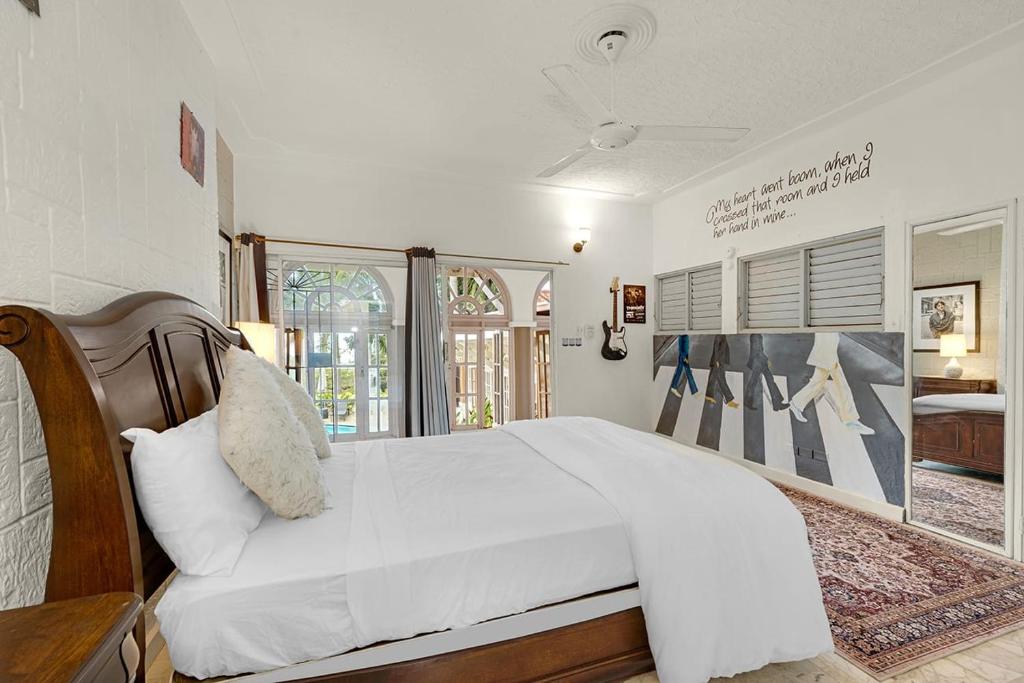 sypialnia z dużym białym łóżkiem i oknem w obiekcie Hospitality Expert McCartney - Tour Pool Bar Beach w mieście Montego Bay