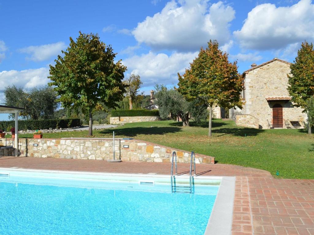 - une piscine en face d'une maison en pierre dans l'établissement Belvilla by OYO Appartamento Giotto, à Serre di Rapolano