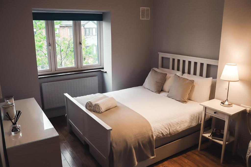 a bedroom with a white bed with a window at Phoenix House in Dublin