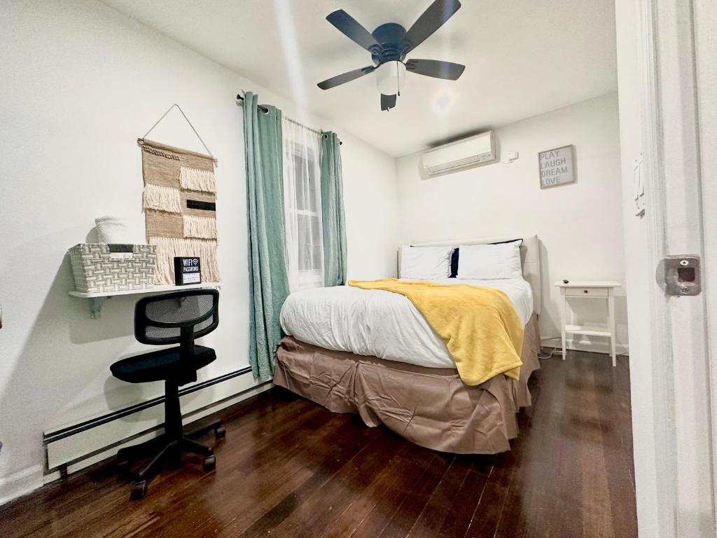 um quarto com uma cama e uma ventoinha de tecto em Peaceful home equal to a sound sleep! em Mastic Beach