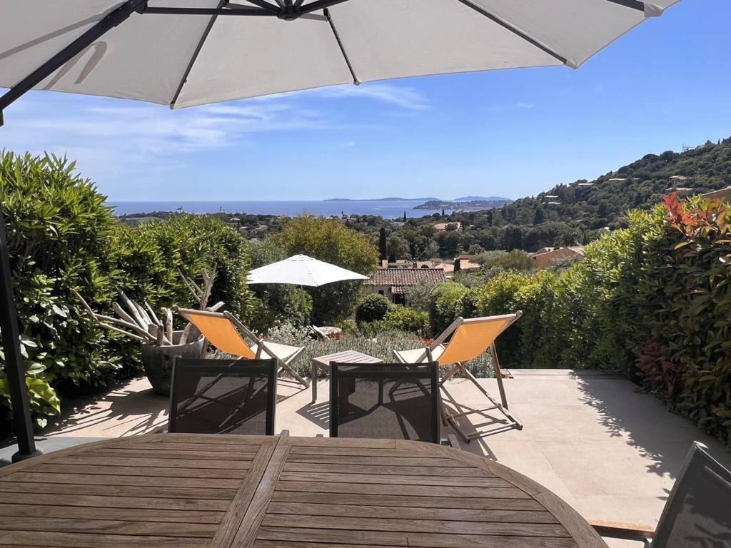 une table en bois avec des chaises et un parasol dans l'établissement Mas 2 chambres avec piscine, tennis, parking et wifi - FR-1-726-24, à La Croix-Valmer