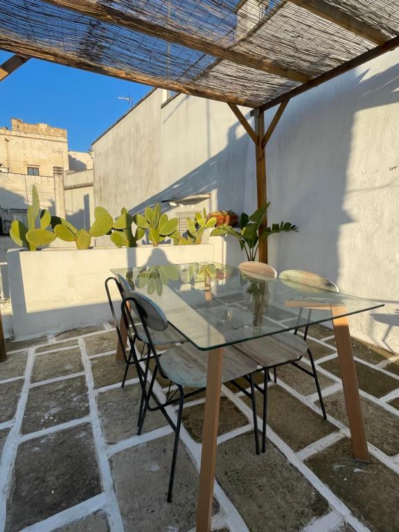 einen Glastisch und Stühle auf einer Terrasse in der Unterkunft Mambo Salentino Guest House in Matino