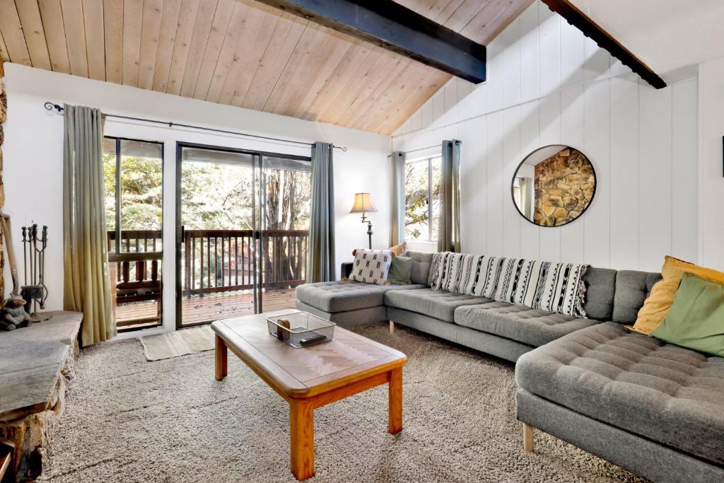 a living room with a couch and a table at Slopeside Views Chalet- Hot Tub- Resort View Cozy Condo in Big Bear Lake