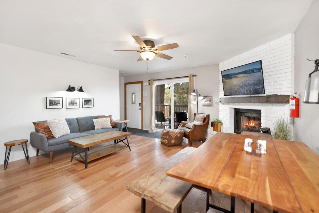 a living room with a table and a fireplace at Brownie's Den- Modern Cozy Central Resort Condo in Big Bear Lake