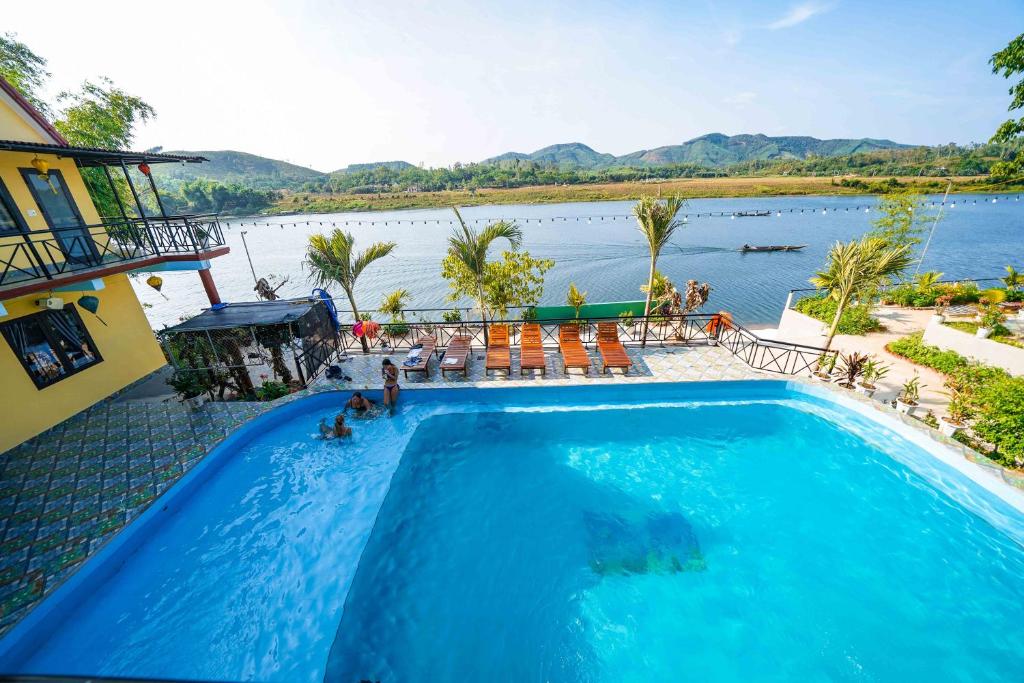 a swimming pool with a view of a body of water at Phong Nha Escape Bungalow in Phong Nha