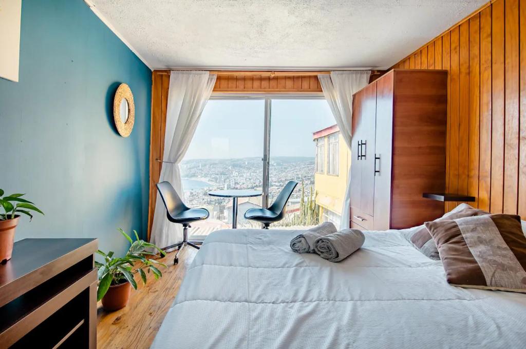 a bedroom with a bed and a large window at Casa Altavista in Valparaíso