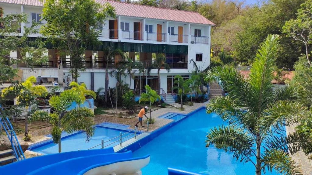 una vista aérea de la piscina del complejo con un hombre en el tobogán en AS Ilaya Resort and Event Place powered by Cocotel en Nasugbu