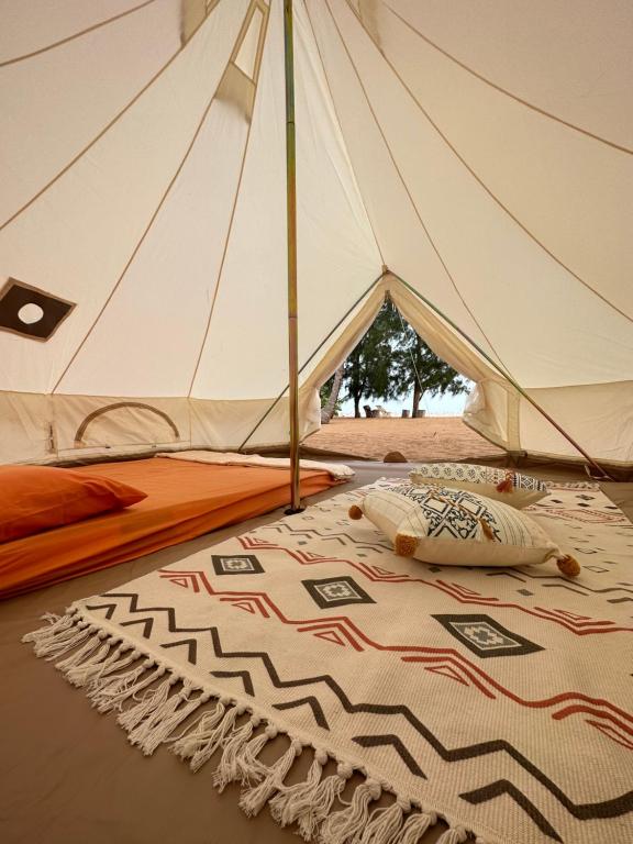 a white tent with a rug on the floor at Beach N Breeze Glamping in Melaka