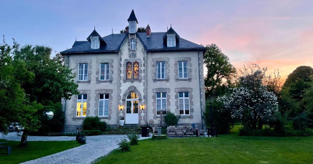 a large white house with a sunset in the background at Villa Vallière bed&breakfast in Vallières