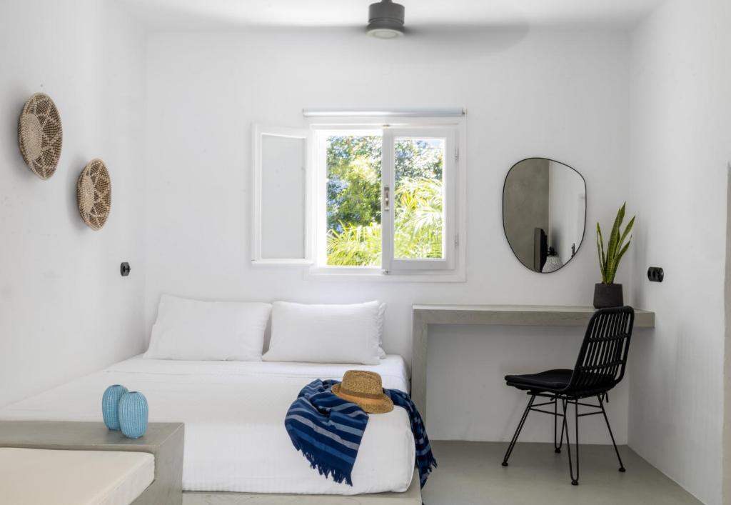 a white room with a bed and a chair at 30villa Rd Studio in Rhodes Town