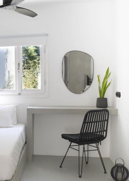 czarne krzesło w białym pokoju z lustrem w obiekcie 30villa Rd Studio w mieście Rodos