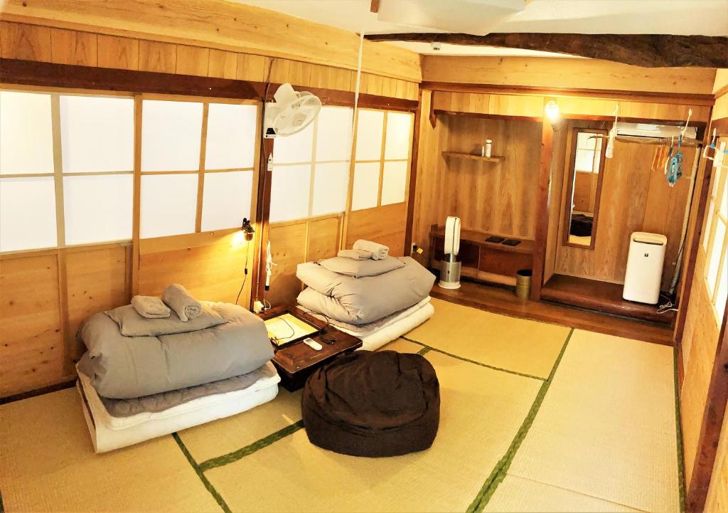 a room with two beds and a table at 奄美ゲストハウス HUB a nice INN in Setouchi