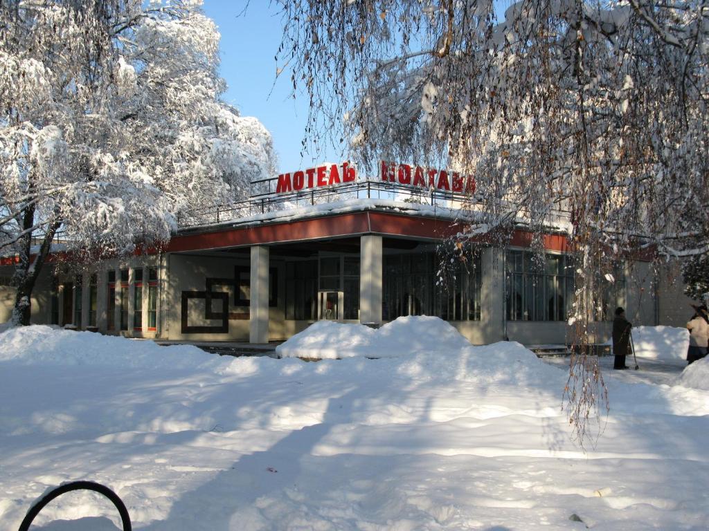 a building with a sign in the snow at Motel Poltava in Poltava