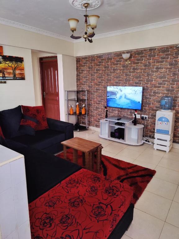 uma sala de estar com um sofá e uma televisão de ecrã plano em Modern 1-bdrm Apartment 15min to CBD. 20min to UN em Nairobi