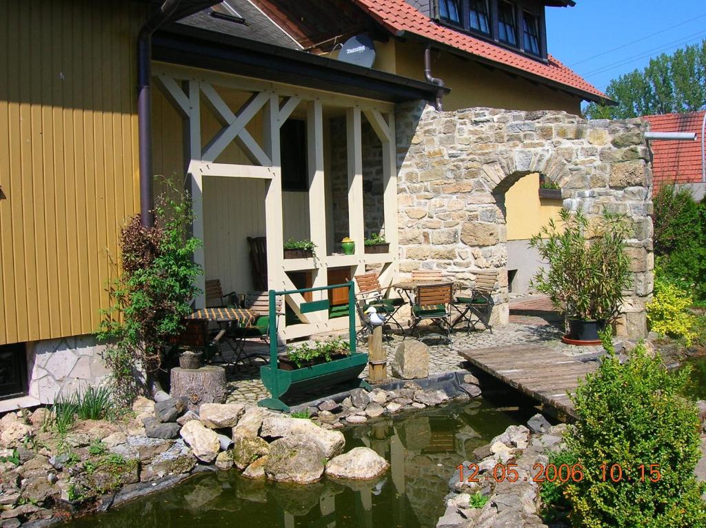 a house with a pond in front of a house at Landferienhaus Pension Erika in Görmar