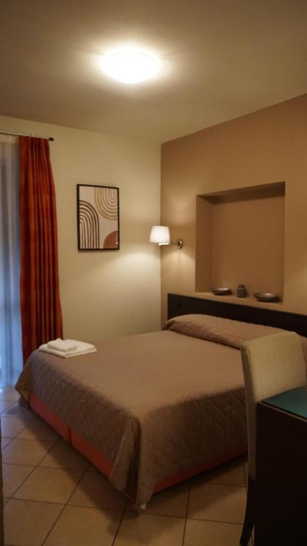 ボルゴマネーロにあるHOTEL DEL CORSOのベッドと鏡が備わるホテルルーム