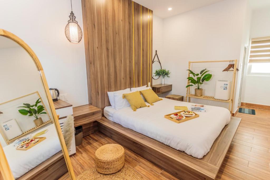 1 dormitorio con cama y espejo en The Morris Dalat Hotel, en Da Lat
