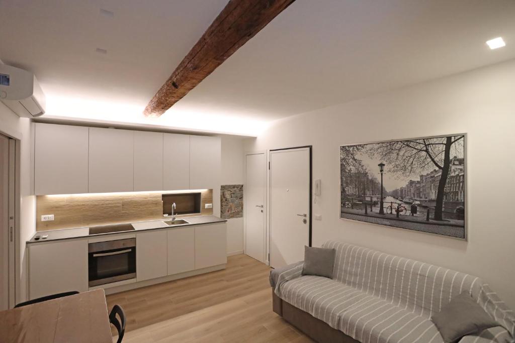 uma sala de estar com um sofá e uma cozinha em La Terrazza del Borgo em Lavagna