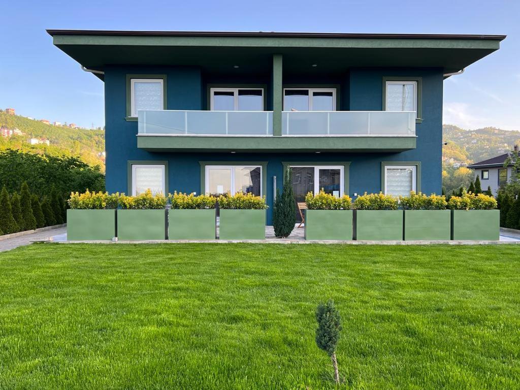 a blue house with a lawn in front of it at Sea and Natural Adalet Suits in Trabzon