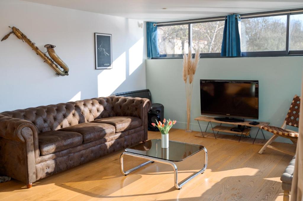 Televízia a/alebo spoločenská miestnosť v ubytovaní Loft sur l'eau en centre-ville de Compiègne