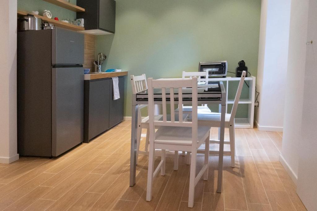 Il comprend une cuisine équipée d'une table avec deux chaises et d'un réfrigérateur. dans l'établissement Flaminio New Apartment, à Rome