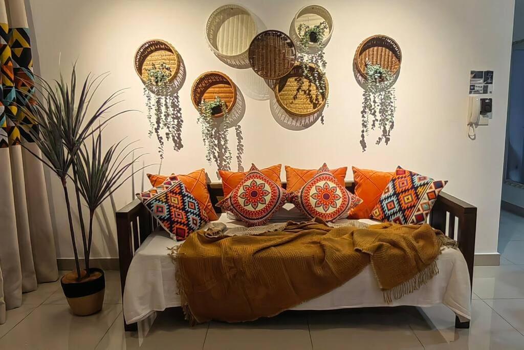 a bed with lots of pillows and mirrors on the wall at BOHO Geniehome 3BR free W-ifi @ Utropolis ShahAlam in Shah Alam