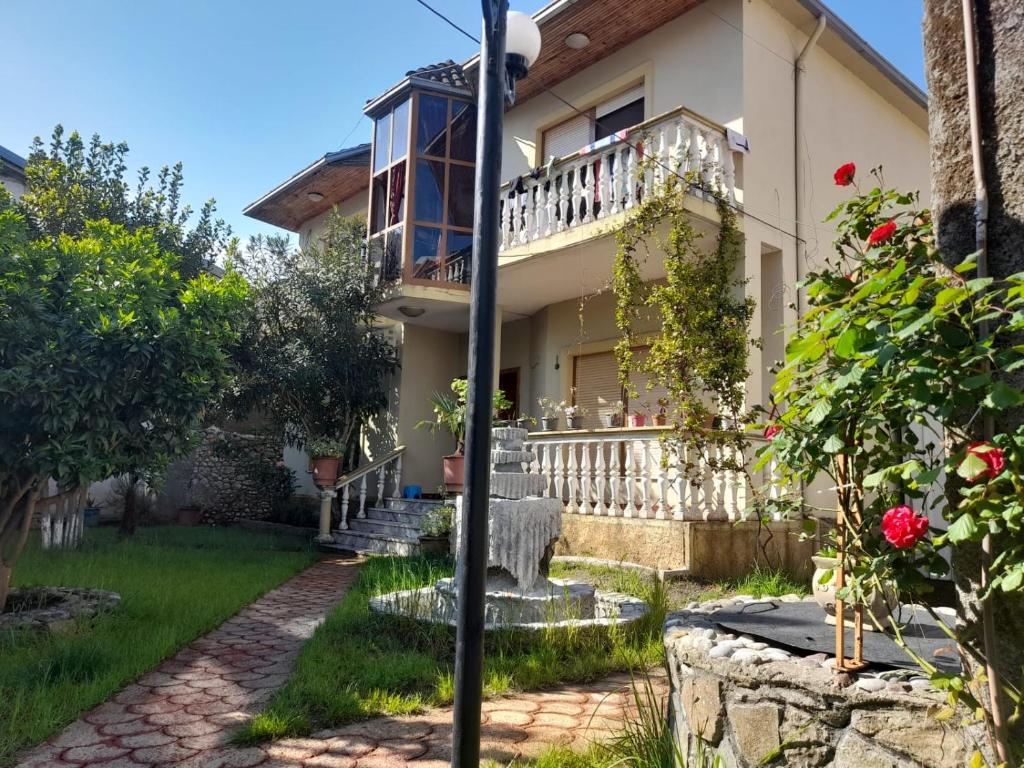 une maison avec un balcon et une cour dans l'établissement Gather Inn Guest House, à Shkodër