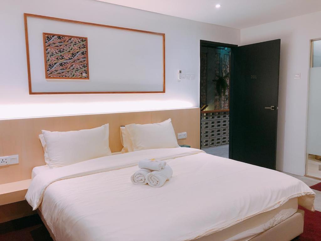 a bedroom with a bed with two towels on it at Domo Japanese Style Bedroom in Malacca