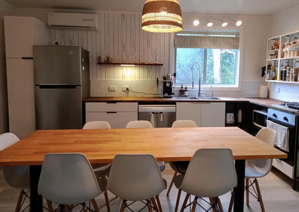 a kitchen with a large wooden table and chairs at Loch Sport Beach Shack - Family Friendly Coastal Retreat in Loch Sport