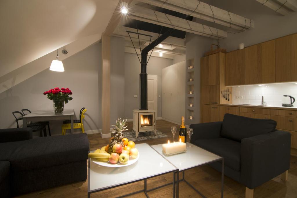 ein Wohnzimmer mit einem Tisch und einem Kamin in der Unterkunft Apartamenty Rynek3 , Kazimierz Dolny in Kazimierz Dolny