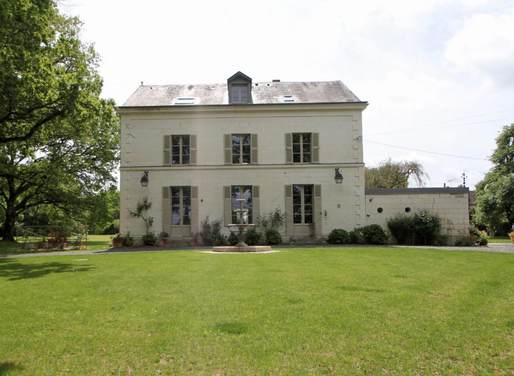 an old white house with a large yard at La Gironnerie in Loché-sur-Indrois