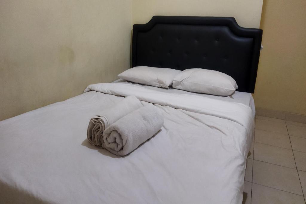 - un lit avec 2 serviettes et 2 oreillers dans l'établissement SPOT ON 92536 Teguh Homestay Syariah, à Parit