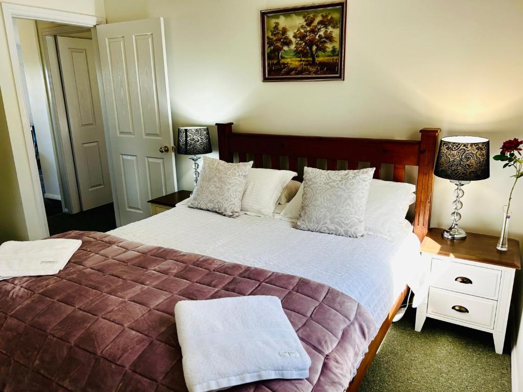 a bedroom with a large bed with white pillows at Red Hill Cottage Walcha in Walcha