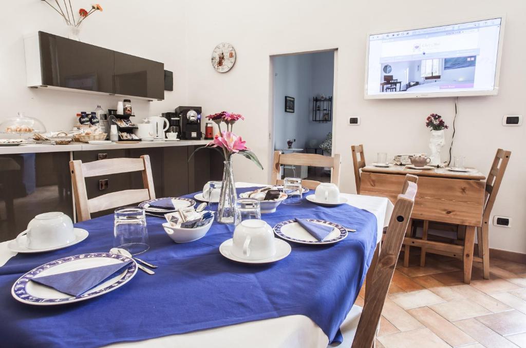フィレンツェにあるキ モイ B & Bのダイニングルームテーブル(青いテーブルクロス付)、皿、食器