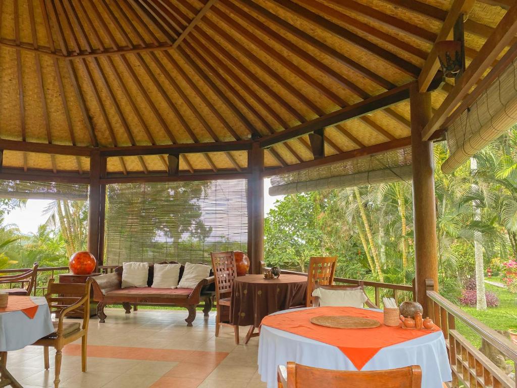 a pavilion with tables and chairs in a restaurant at Cabé Bali in Jasri