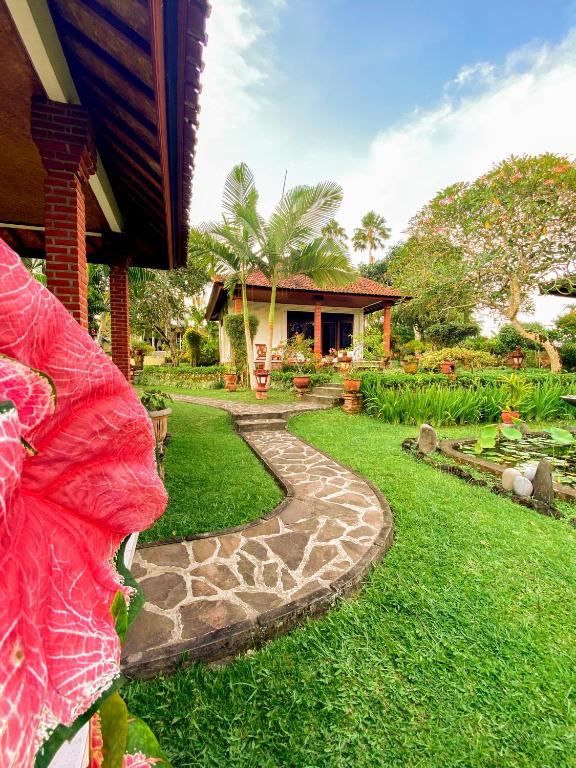 a house with a garden with a walkway at Cabé Bali in Jasri