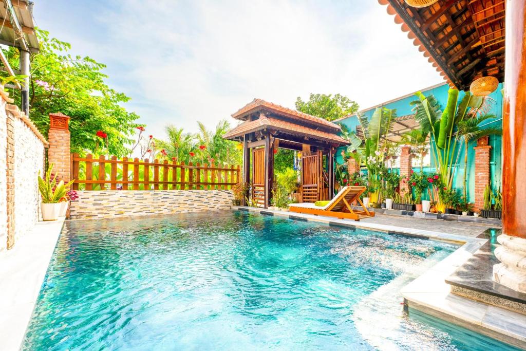 - une piscine avec un kiosque à côté d'une maison dans l'établissement Eco Wooden villa Hoi An, à Hội An