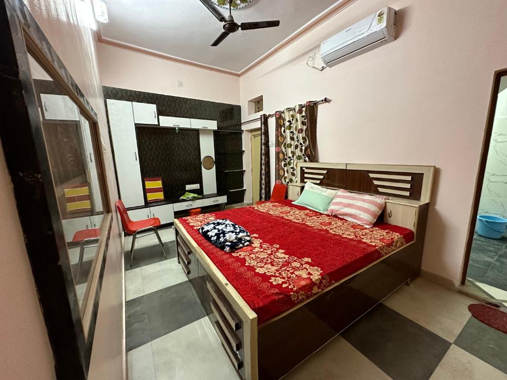 a bedroom with a bed with a red comforter at m.i. guest house in Bikaner