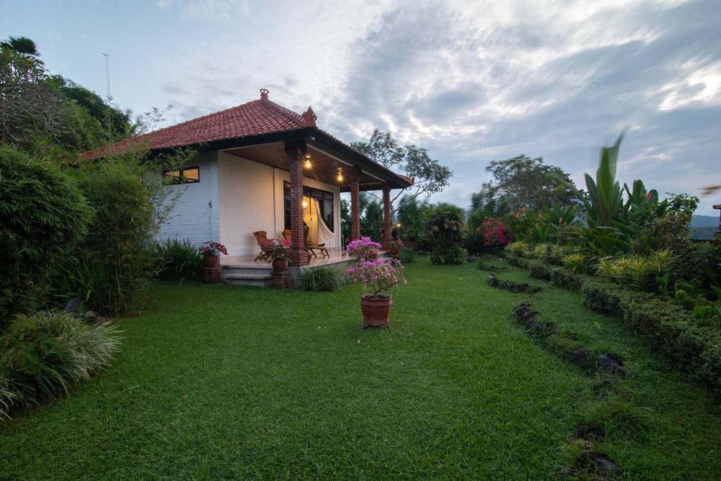 a small house with a green yard next to it at Cabé Bali in Jasri