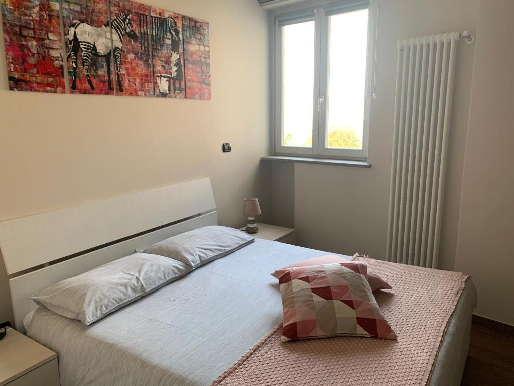 a bedroom with a bed and a window at A Casa di Viola - Appartamento in La Morra