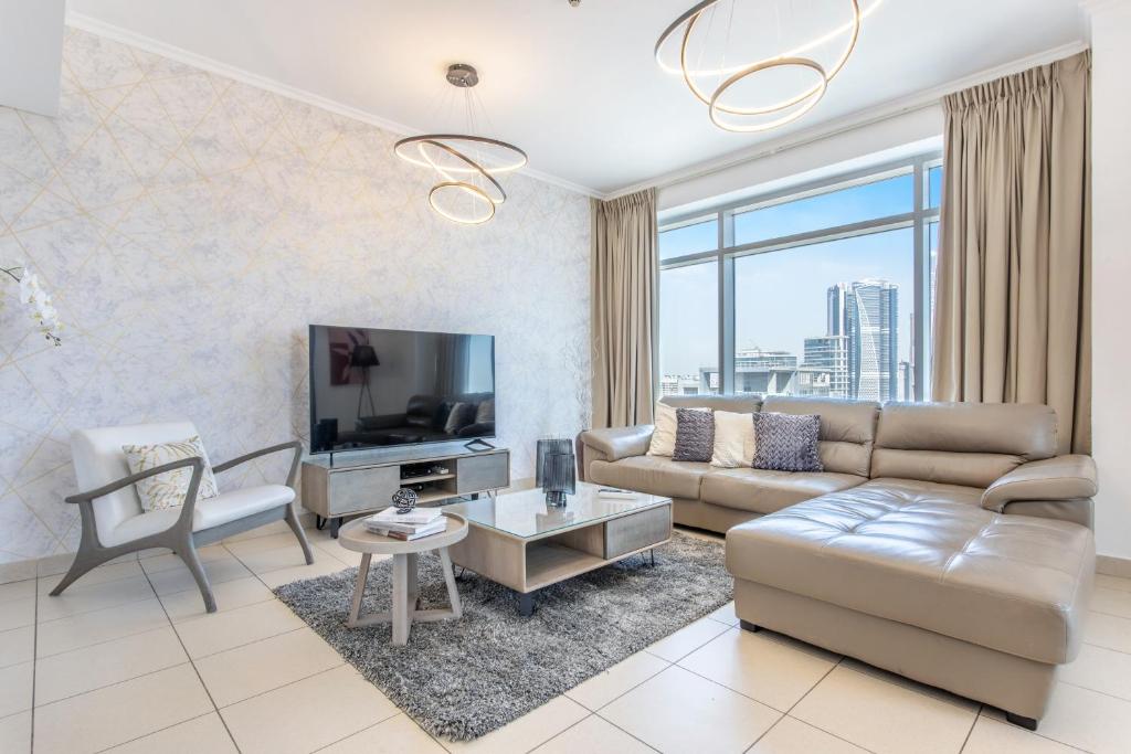 a living room with a couch and a tv at Icon Casa Living - Downtown Burj Views Towers in Dubai