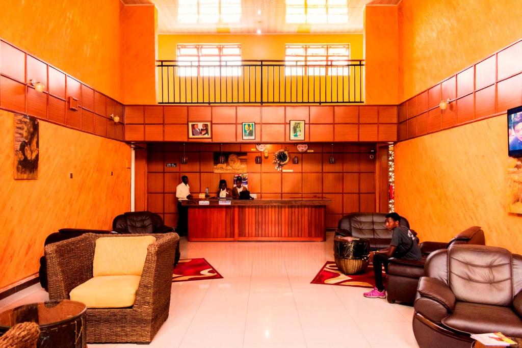 a lobby with chairs and a bar in the center at Kalya Courts Hotel Fort Portal in Fort Portal