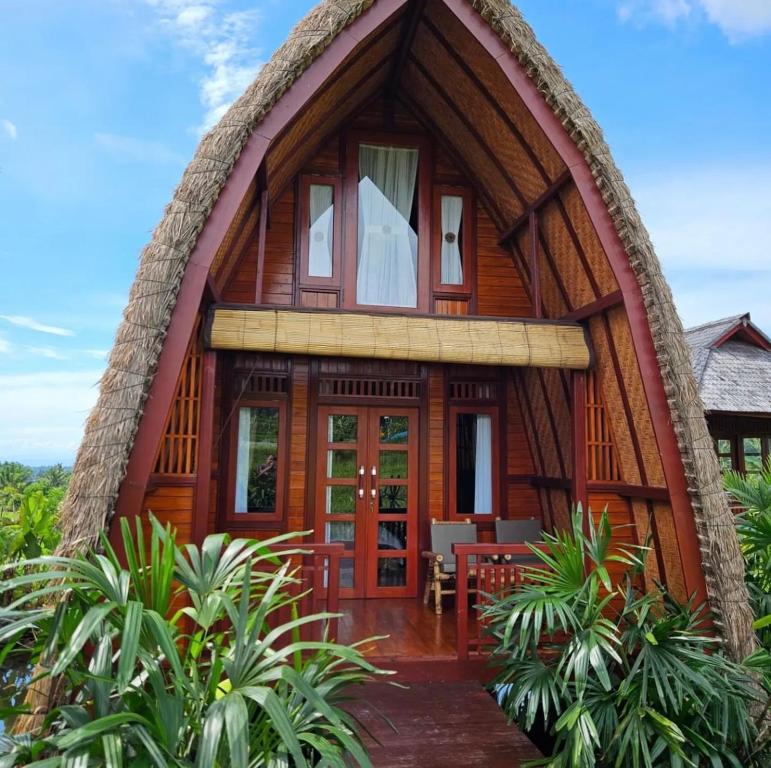 a wooden house with a round roof at Cabé Bali in Jasri