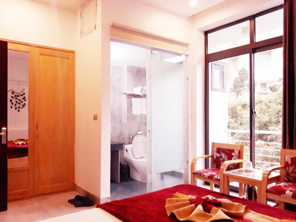 a bedroom with a bed and a bathroom with a toilet at Đức An Hotel in Tam Ðảo
