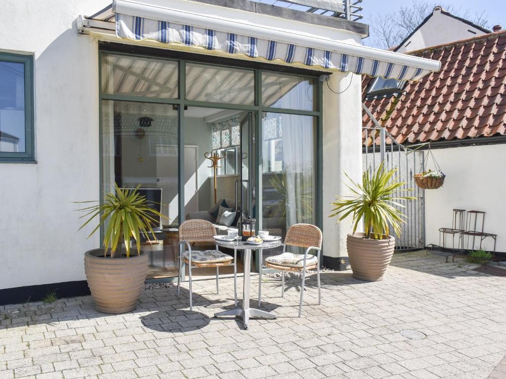 a patio with two chairs and a table with plants at Reedham Retreat in Reedham