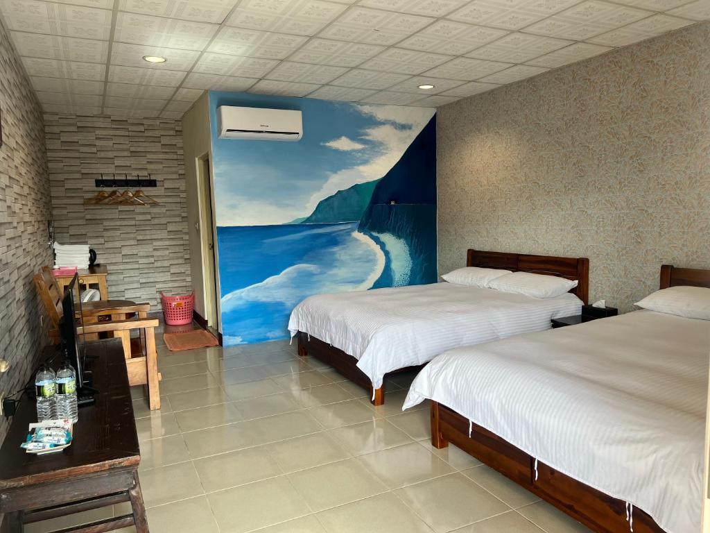 a room with two beds and a painting on the wall at Golden flower Homestay in Yuli