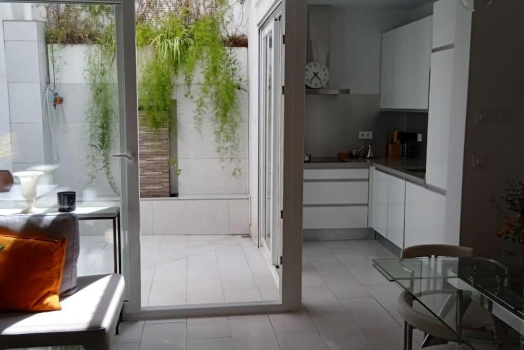 uma cozinha com uma grande porta de vidro que leva a uma sala de estar em El patio de Nervión. em Sevilha
